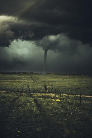 Tornado tearing through a field during stormy weather